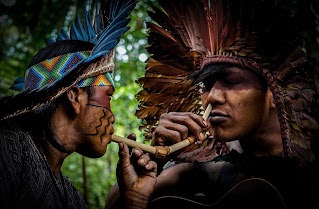 Huni Kuin men applying Rapé to each other in the forest